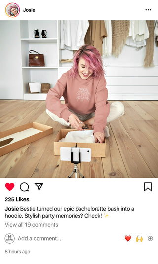 Josie laughs joyfully as she unboxes a Maison Memoire custom hoodie, capturing the happy memories of her bachelorette party.