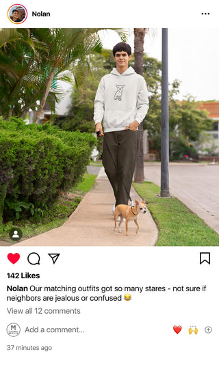 Nolan grins while walking his dog, both donning matching Maison Memoire apparel, making a fun fashion statement in their neighborhood.